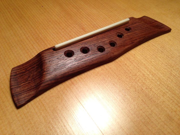 The bridge made from Honduran Rosewood. Carved to be similar to the original design, attached with hide glue.